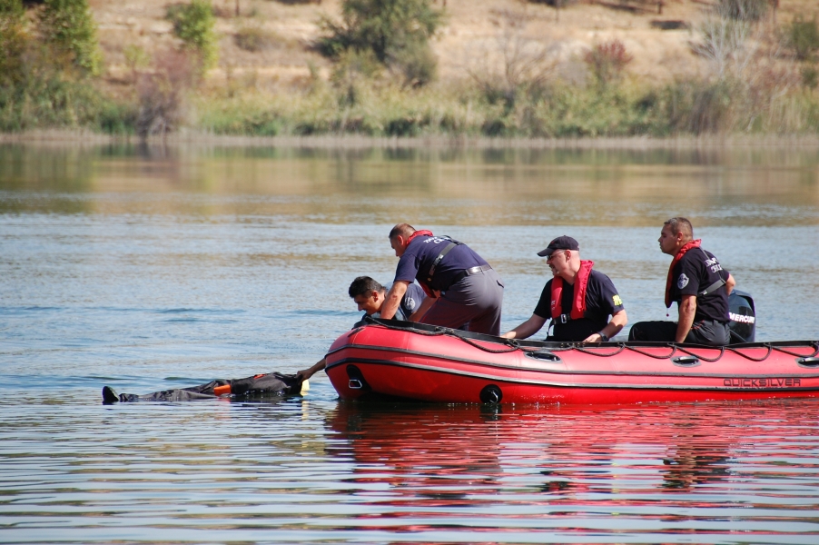 Feuerwehrteam im Schlauchboot trainiert auf dem Fluss, einen Menschen aus dem Wasser zu retten