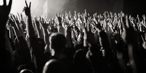 schwarz-weiß-Foto mit jubelnden KonzertbesucherInnen