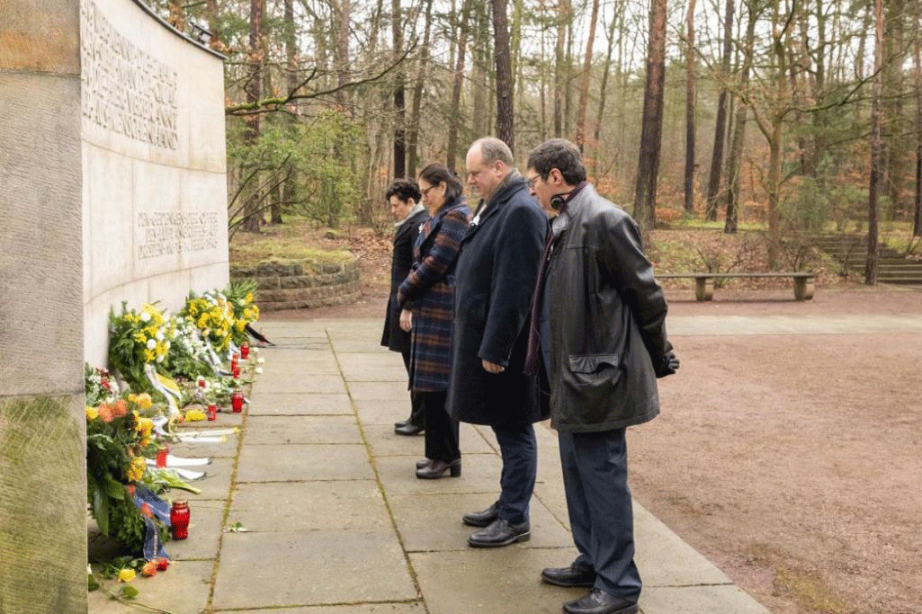 Menschengruppe vor der Gedenkmauer für die Opfer der Bombardierung Dresdens, Blumen, Kränze