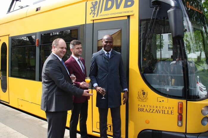 Oberbürgermeister Dirk Hilbert steht mit Kulturbürgermeister René Bobala aus Brazzaville und DVB-Vorstand Lars Seiffert vor der Brazzaville-Bahn