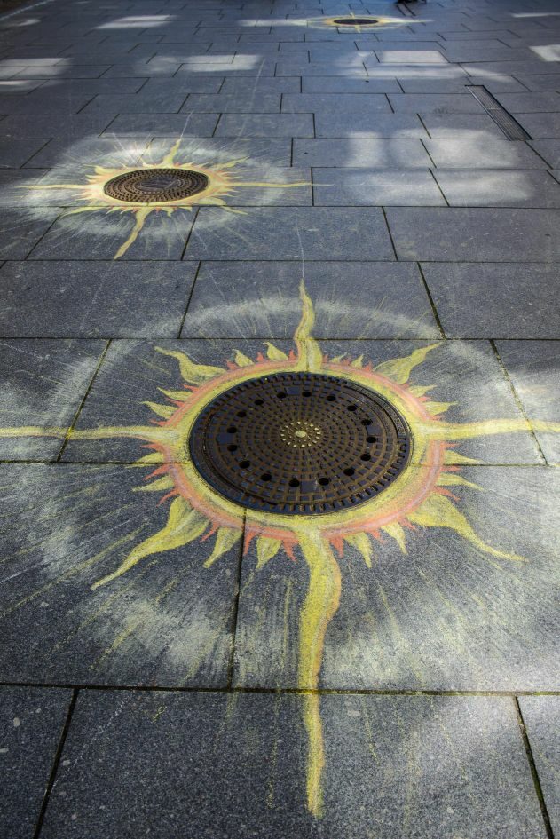 mit Farbkreide bemalte Gullidecke auf der Kreuzstraße, Motiv Sonne