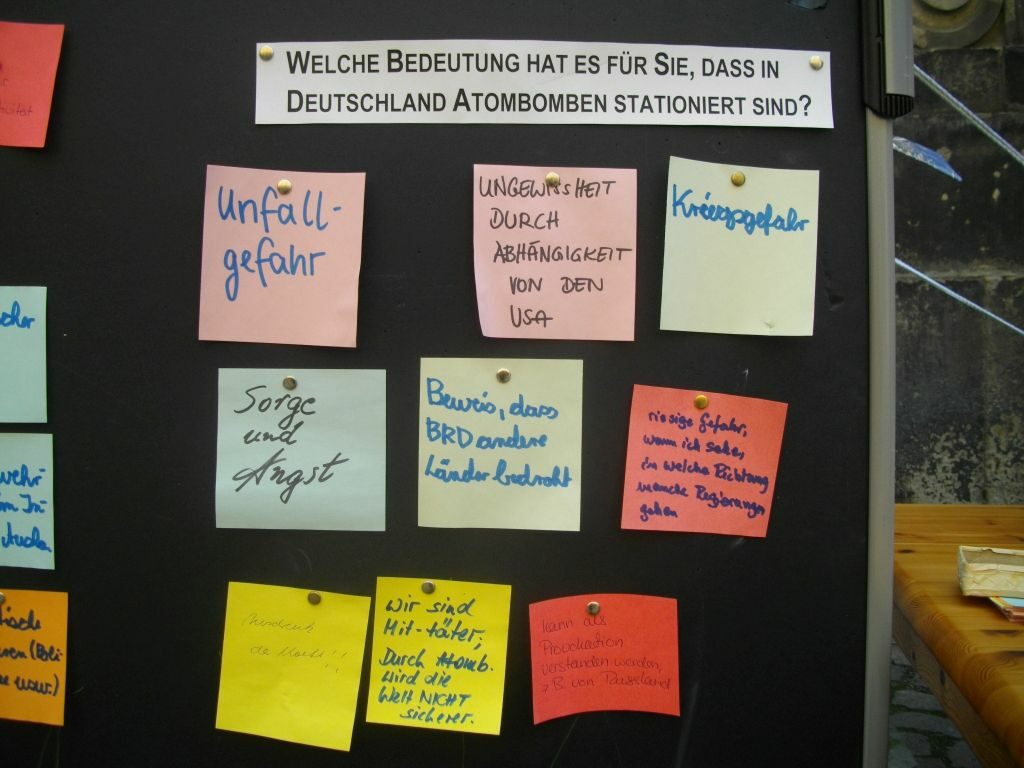 Passantenbefragung: Zettel auf einer Pinwand mit Antworten auf die Frage: "Welche Bedeutung hat es für Sie, dass in Deutschland Atomwaffen stationiert sind?"