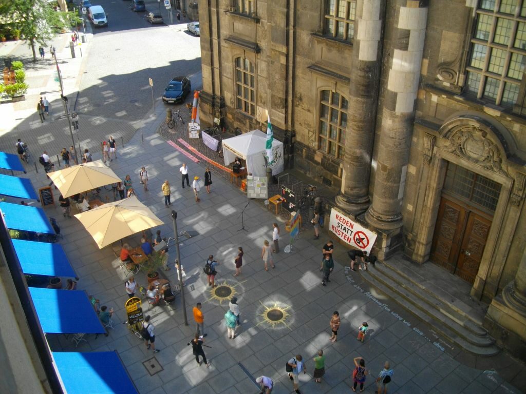 Mahnwache aus der Luft aufgenommen mit Straßenmalerei, Infostand und Menschen