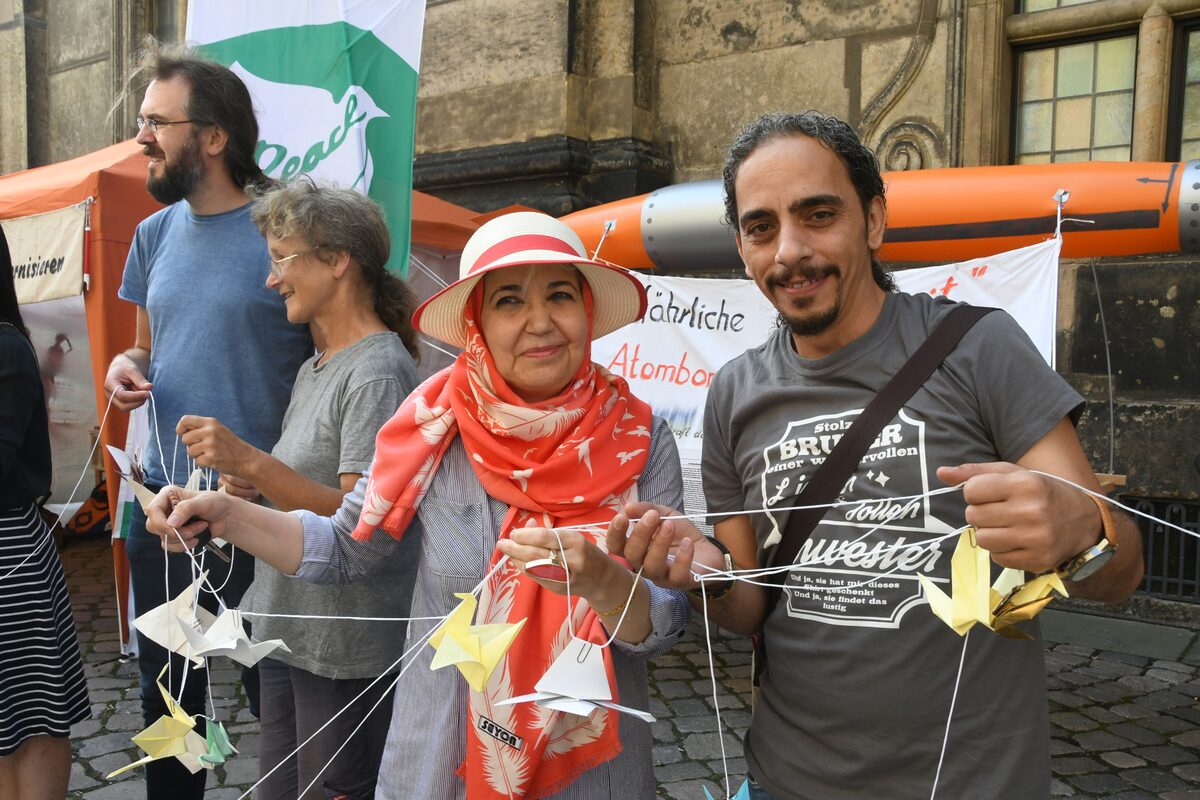 2 Menschen mit ihren Papierkranichen