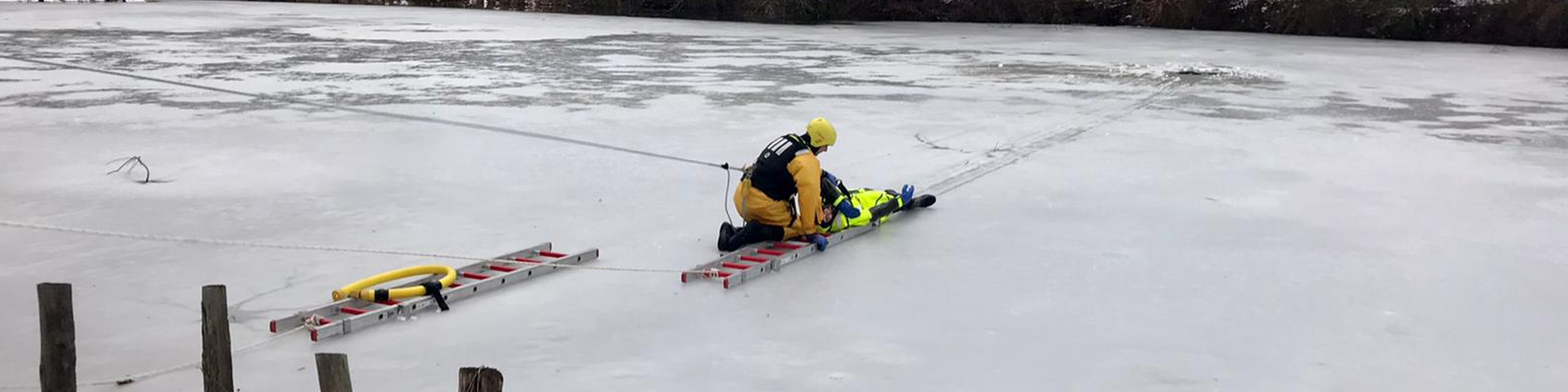 Ein Feuerwehrmann bei der Rettung einer Person, die ins Eis eingebrochen ist.
