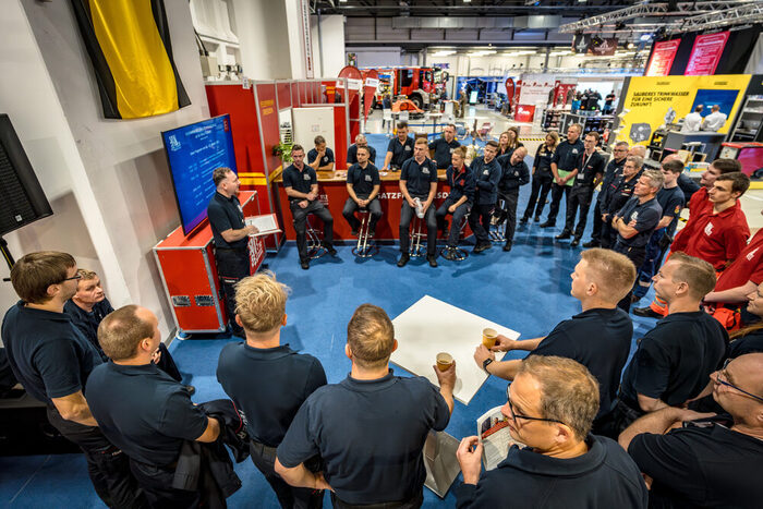 Das Messeteam bereitet sich beim Morgenbriefing auf den Messetag vor.