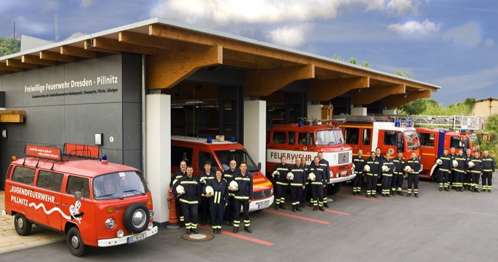 STF Pillnitz: Fahrzeuge und Feuerwehrleute vor dem Gerätehaus