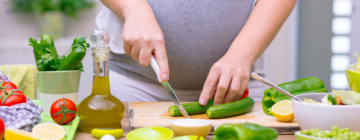 Schwangere Frau bereitet verschiedenes Gemüse vor