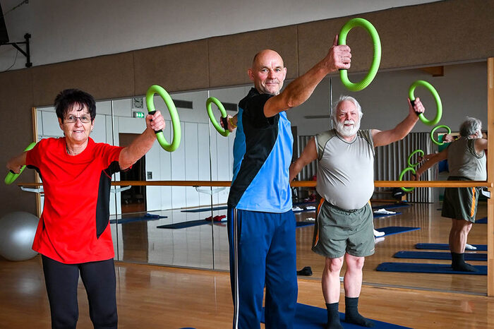 Drei ältere Personen üben ein Ganzkörpertraining mit Smovey-Ringen aus