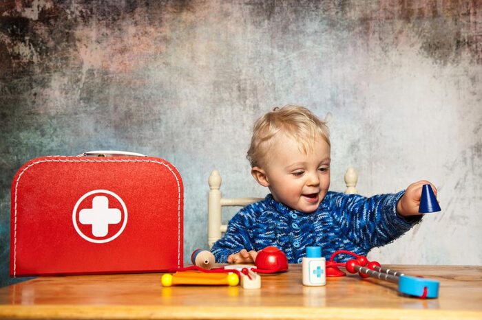ein Junge spielt mit einem Spielzeug-Medizinkoffer