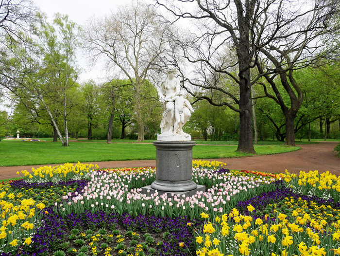 Osterglocken, Tulpen und Stiefmütterchen um die Skulptur im Bürgerpark