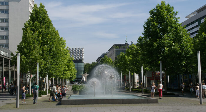 Fußgängerzone mit Bäumen und Pusteblumenbrunnen