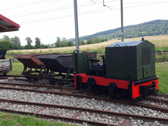 kleine offene Lokomotive mit zwei Tendern auf Gleisen