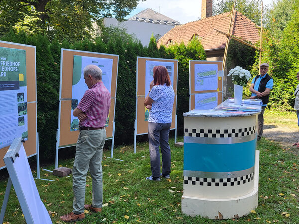 Menschen stehen vor Pinnwänden, die Plakate mit Ergebnissen des Projektes Green Urban Labs zeigen