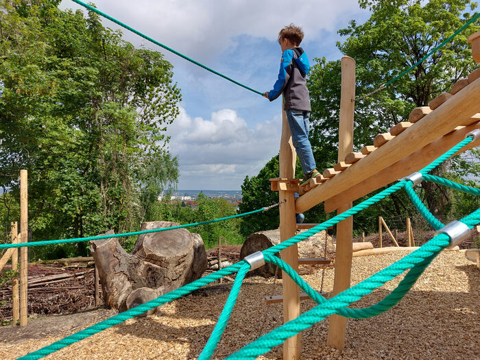 Waldspielplatz im Südpark - Junge auf einem mit grünen Kletternetzen bespannten Klettergerüst