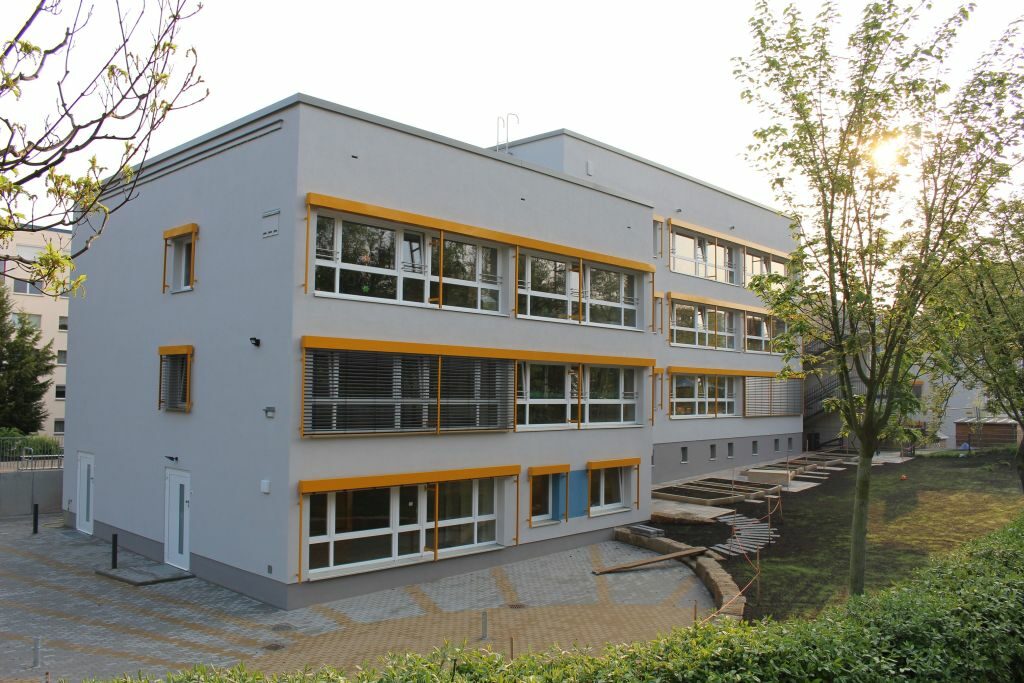 Rückansicht mit großen Fenstern und Pausenhof