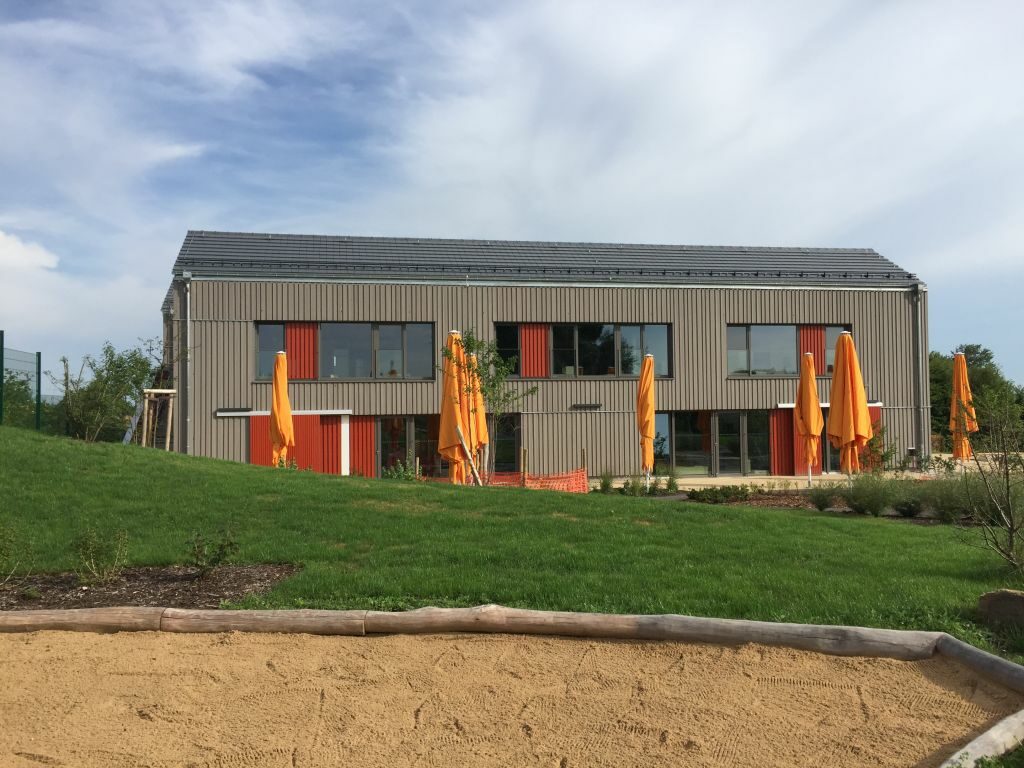 Außenansicht mit Sonnenschirmen und Wiese