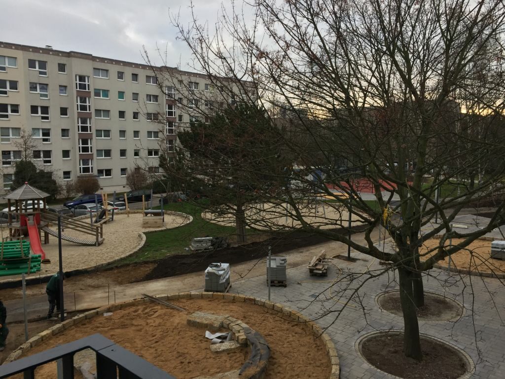 Blick auf den großen Innenhof mit Spielgeräten und Sandkästen