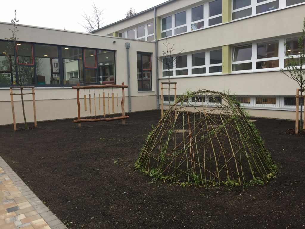 Blick in den Innenhof Mit Bäumen und Holzspielzeug