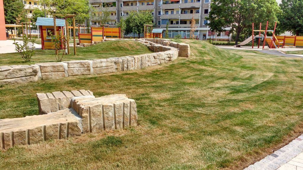 Freianlagen der Kita Malterstraße mit Klettergeräten und Sandsteinelementen