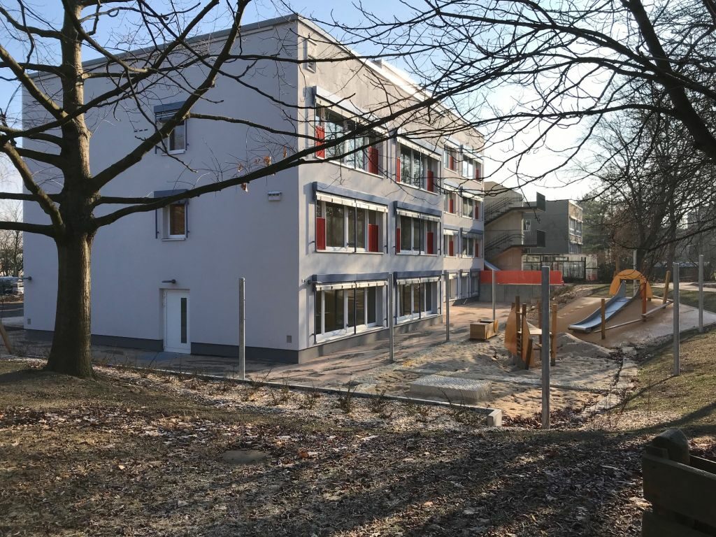Außenansicht des sanierten Kita-Gebäudes mit Blick auf den Spielplatz
