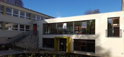 Blick schräg auf den Haupteingang mit herunterführender Treppe