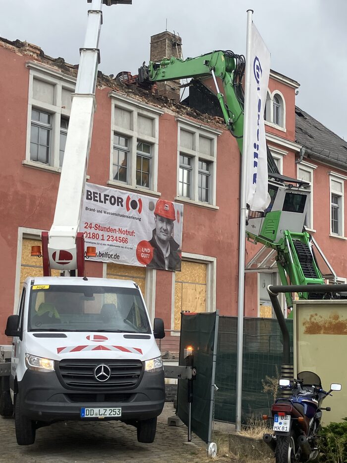 Bagger reißen das Dach eines Hauses ab Bagger reißen das Dach eines Hauses ab