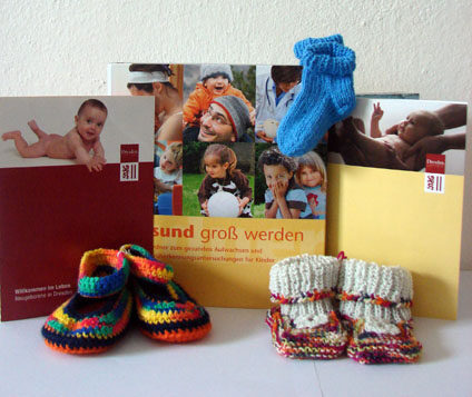 Broschüren und handgestrickte Babyschuhe, die als Geschenk beim Begrüßungsbesuch überreicht werden