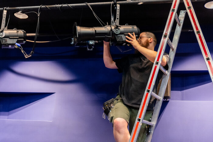 Thomas stellt auf der Leiter die Beleuchtung ein