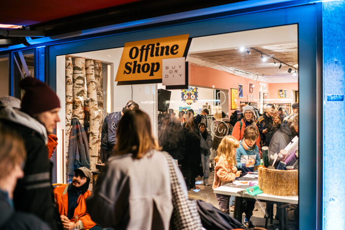 Menschen vor einem Schaufenster mit der Beschriftung "Offline Shop"