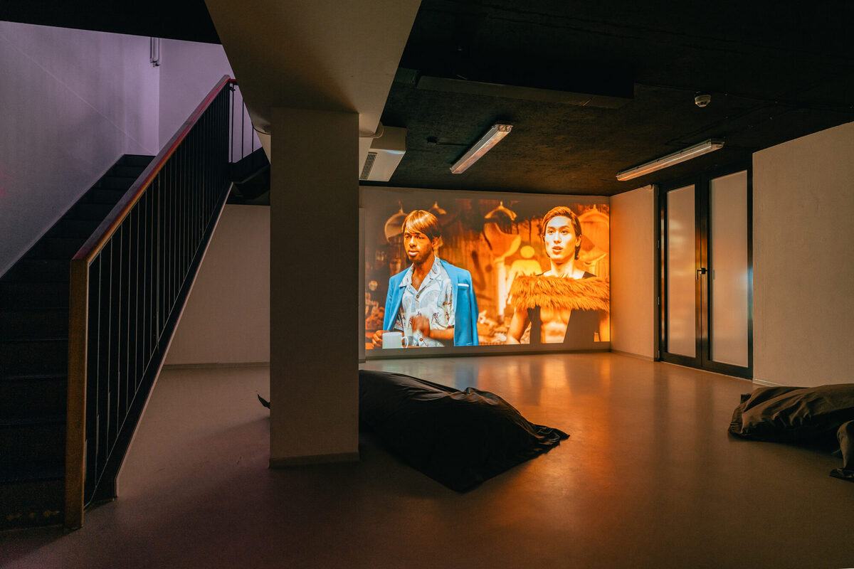 Leerer Raum mit Film-Projektion an einer Wand und Sitzkissen auf dem Boden