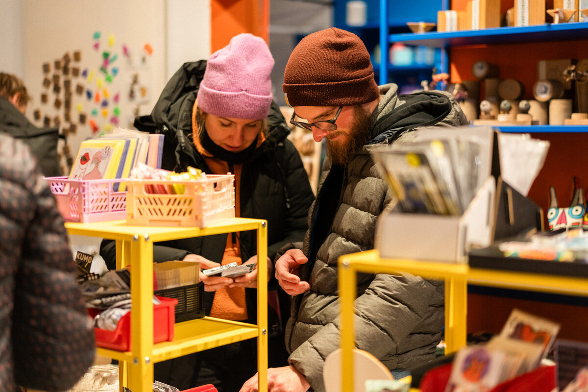 Ein Laden mit verschiedenen Regalen in denen Postkarten, SChmuck, Poster und andere Kunstgegenstände ausgestellt sind.