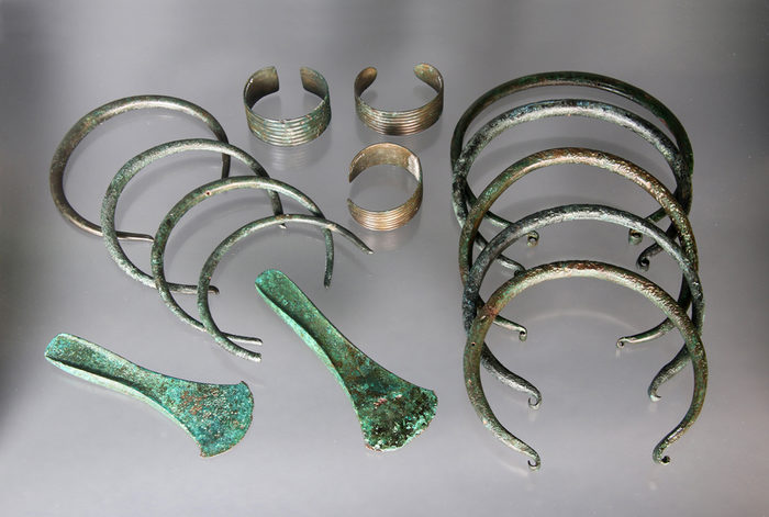 Foto eines Depotfunds in Prohlis mit Halsringen, Armbändern und Beilklingen aus Bronze.
