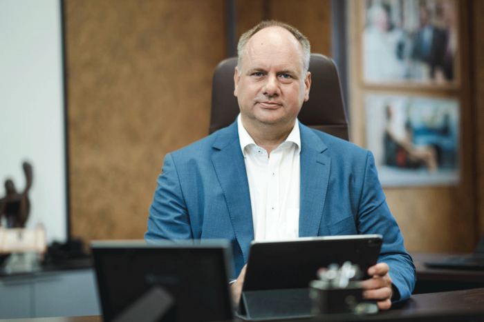 Oberbürgermester Dirk Hilbert sitzt an seinem Schreibtisch und hat zwei Tablets vor sich stehen.