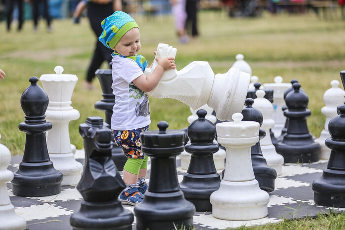 kleines Kind mit großen Schachfiguren