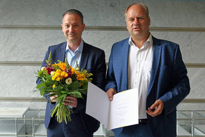Bürgermeister Jan Donhauser mit Blumenstrauß, Oberbürgermeister Dirk Hilbert hält die Ernennungsurkunde