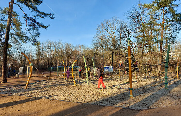 Foto von einem Spielplatz im Winter, darauf ein paar spielende Kinder