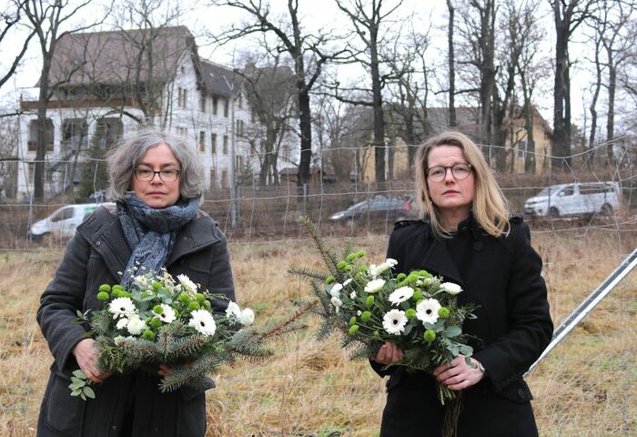 Umweltbürgermeisterin Eva Jähnigen (li.) und Kulturbürgermeisterin Annekatrin Klepsch legen Blumengebinde im stillen Gedenken an die Zwangsarbeiter in der NS-Diktatur nieder