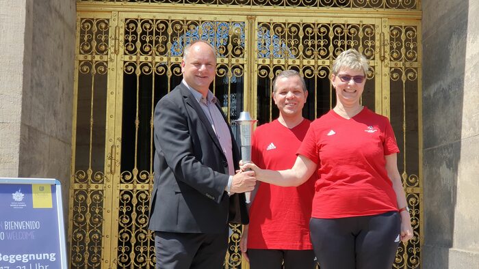 Oberbürgermeister und zwei Sportler Dresden bei der Fackelübergabe vor der Goldenen Pforte