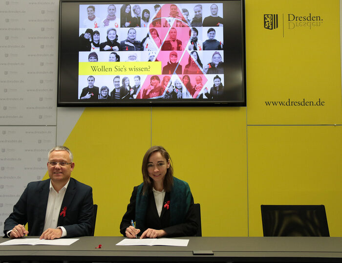 Zwei Personen an einem Tisch unterschreiben eine Deklaration