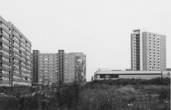 Hochhäuser in Schwarz-Weiß, eines davon mit einem großen Wandbild