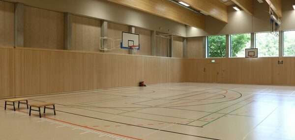 Blick auf die Sportfläche der Sporthalle mit hellem Boden und Linien