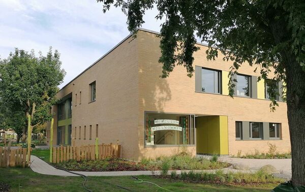 Haus mit einer Fensterscheibe, auf der "Herzlich Willkommen" steht