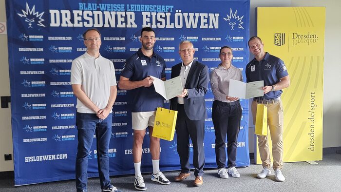 Mehrere Personen zeigen ihre Einbürgerungsurkunde