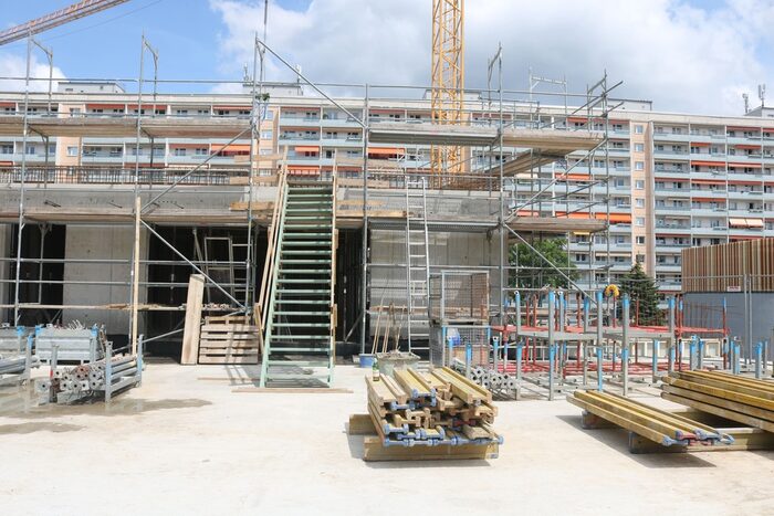 Außenansicht eines Rohbaus mit provisorischer Treppe, die aufs Dach führt