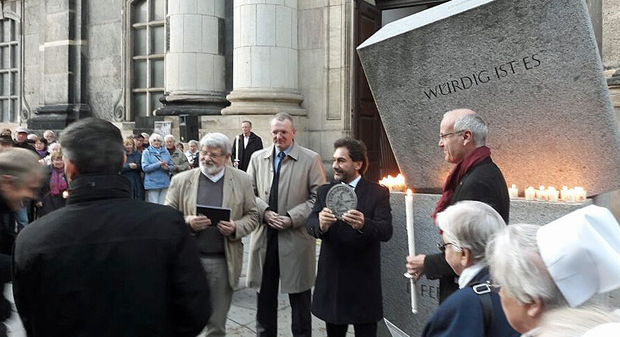 Gedenken vor der Kreuzkirche - Menschen und Kerzen am Gedenkstein