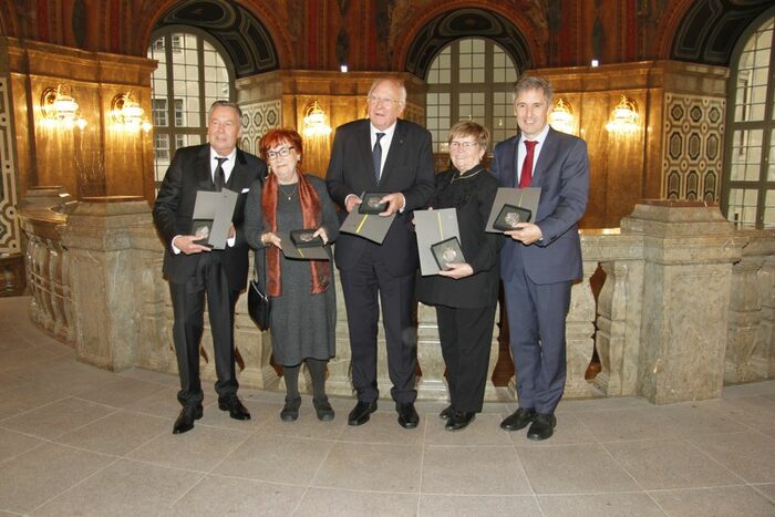Nora Goldenbogen, Ernst Hirsch, Roland Kaiser, Nora Lang und Frank Richter stehen mit ihren Ehrenmedaillen in der Kuppelhalle des Dresdner Rathauses.