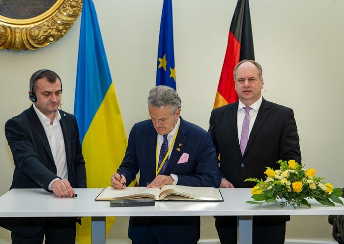 Die Oberbürgermeister von Stuttgart und Chmelnyzkyj tragen sich in das Goldene Buch ein.