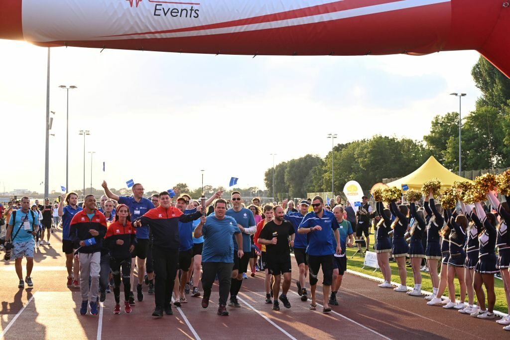 Der Fackellauf erreicht die Ziellinie im Sportpark Ostra, begleitet von den Happy Drummers und den Cheerleadern der Dresden Monarchs