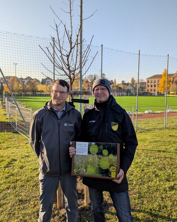 Abteilungsleiter Nico Seidel übergibt Denis Kruppa das Schild, das auf die Naturschutzmaßnahmen hinweist